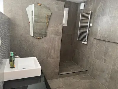 a bathroom with a sink and a shower with a mirror at Modern villa 5 double bedrooms, new AC, private pool and stunning view 800 m from beach in Sagone