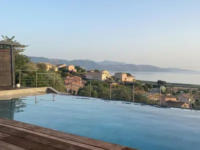 a swimming pool with a view of the water at Modern villa 5 double bedrooms, new AC, private pool and stunning view 800 m from beach in Sagone