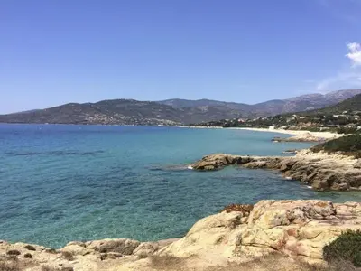 a view of a beach with mountains in the background at Modern villa 5 double bedrooms, new AC, private pool and stunning view 800 m from beach in Sagone