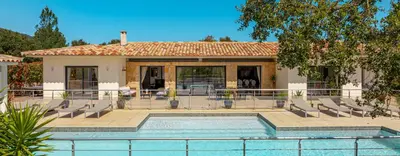 a house with a swimming pool in front of a house at Villa Les Arbousiers - Piscine Chauffée Sécurisée - 210m2 - 4 Suites in Porto-Vecchio