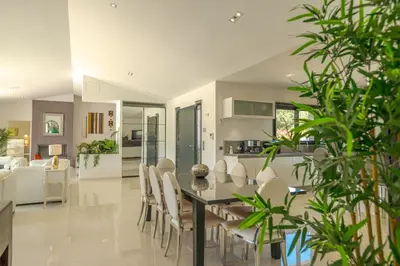 a dining room and kitchen with a table and chairs at Villa Les Arbousiers - Piscine Chauffée Sécurisée - 210m2 - 4 Suites in Porto-Vecchio
