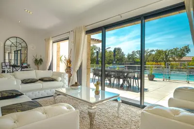 a living room with a couch and a table at Villa Les Arbousiers - Piscine Chauffée Sécurisée - 210m2 - 4 Suites in Porto-Vecchio