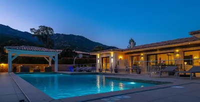 a house with a swimming pool in front of a house at Villa Les Arbousiers - Piscine Chauffée Sécurisée - 210m2 - 4 Suites in Porto-Vecchio