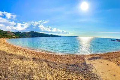 a beach with the sun shining on the water at Villa Jeannette in Grosseto-Prugna
