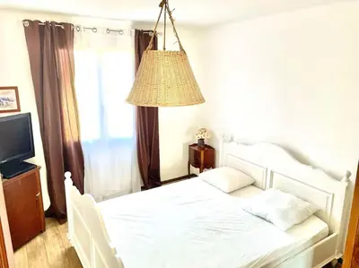 a bedroom with a white bed and a lamp at Villa Jeannette in Grosseto-Prugna