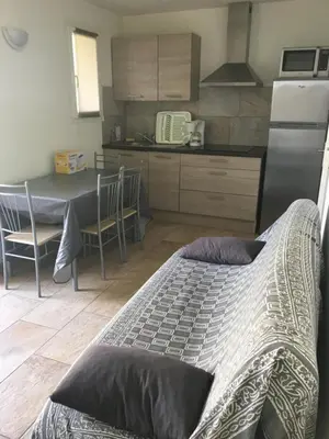 a kitchen with a table and a kitchenasteryasteryasteryasteryasteryasteryasteryastery at Appartement proche des plus belles plages in Porto-Vecchio