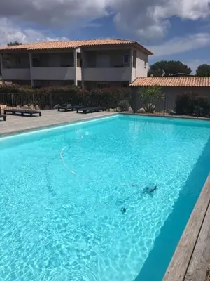 a large blue swimming pool in front of a house at Appartement proche des plus belles plages in Porto-Vecchio