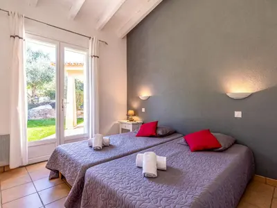 a bedroom with two beds with red and white pillows at Villa Corba Bala by Interhome in Porto-Vecchio