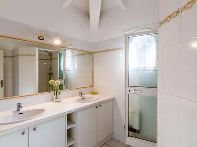 a bathroom with two sinks and a mirror at Villa Corba Bala by Interhome in Porto-Vecchio