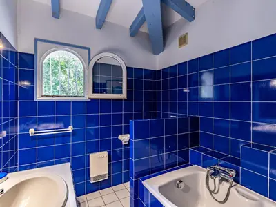 a blue tiled bathroom with a tub and a sink at Villa Corba Bala by Interhome in Porto-Vecchio