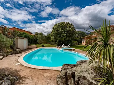 a swimming pool in a yard with chairs around it at Villa Corba Bala by Interhome in Porto-Vecchio