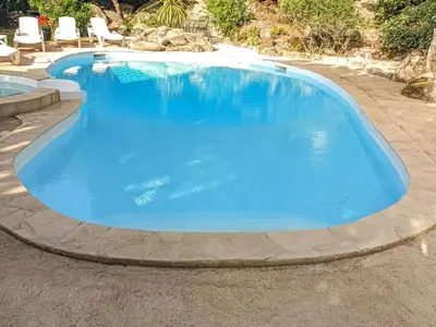 a large pool with blue water in a patio at Villa Corba Bala by Interhome in Porto-Vecchio
