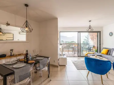 a kitchen and living room with a blue chair at Apartment Cita Di Sali 13 by Interhome in Porto-Vecchio