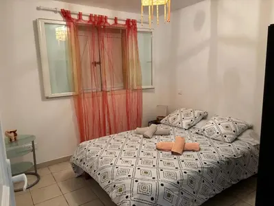 a bedroom with a bed and a red curtain at Maison de charme à Ajaccio avec terrasse et jardin in Ajaccio