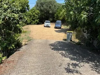 two cars parked on a dirt road with trees at Maison de charme à Ajaccio avec terrasse et jardin in Ajaccio