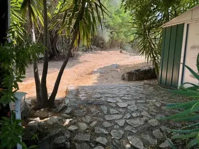 a dirt road next to a building with a tree at Maison de charme à Ajaccio avec terrasse et jardin in Ajaccio