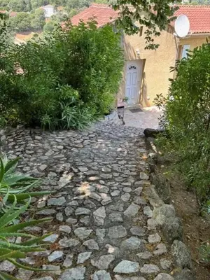 a stone path leading to a house with a door at Maison de charme à Ajaccio avec terrasse et jardin in Ajaccio