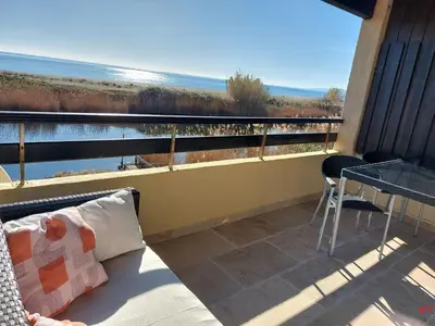 a balcony with a table and a view of the water at Vista Mare Ghisonaccia in Ghisonaccia