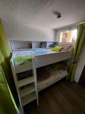 a bunk bed with a ladder in a small room at Vista Mare Ghisonaccia in Ghisonaccia