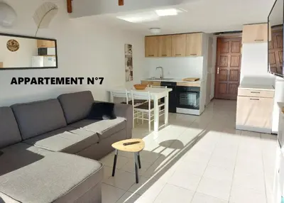 a living room with a couch and a kitchen at Vista Mare Ghisonaccia in Ghisonaccia