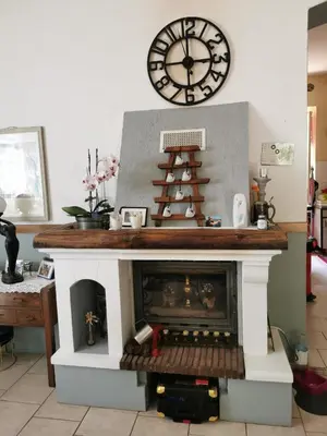 a fireplace with a clock above it with a christmas tree at Casa Maria in Vico
