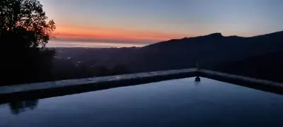 a pool with a sunset in the background at Domaine COLONNA SANTINI ,Chambre d hôtes Piscine, Spa in Porri