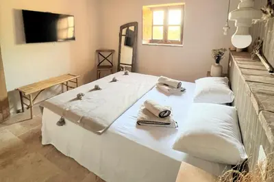 a large white bed with pillows and towels on it at Casetta Soli Di Santa Lucia in Sainte-Lucie de Porto-Vecchio