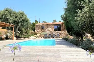 a pool in a yard with chairs and a house at Casetta Soli Di Santa Lucia in Sainte-Lucie de Porto-Vecchio