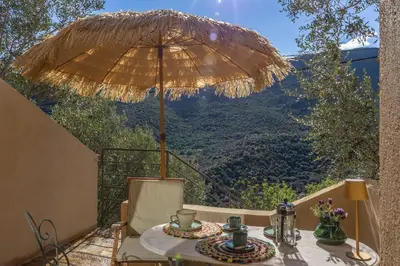 a small yellow building with two chairs and a table at Maison A Luna in Palasca