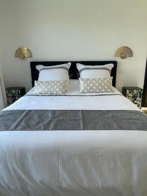 a large white bed with two pillows on it at Villa neuve avec grande piscine chauffée vue mer in Conca