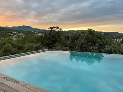 a large swimming pool with a view of the mountains at Villa neuve avec grande piscine chauffée vue mer in Conca