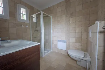 a bathroom with a toilet and a sink and a shower at Maisons Jumelées in Piana