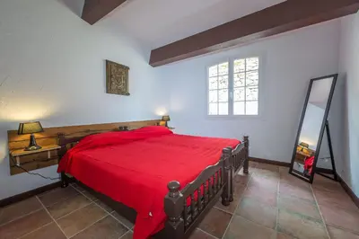 a bedroom with a red bed and a window at Maisons Jumelées in Piana