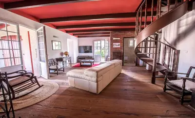 a living room with a couch and a staircase at Maisons Jumelées in Piana