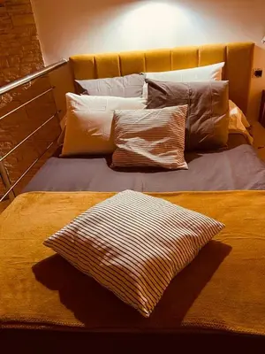 a bed with several pillows on top of it at VILLA SANTONI in Porticcio