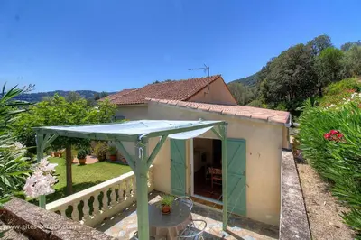 a small house with a blue umbrella on a balcony at L'AMANDIER -LE FIGUIER-LES LAURIERS ROSES in Ajaccio