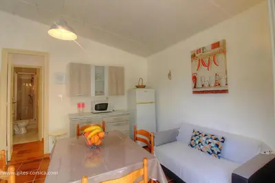 a living room with a table and a couch at L'AMANDIER -LE FIGUIER-LES LAURIERS ROSES in Ajaccio