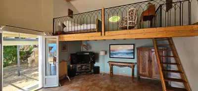 a living room with a loft bed and a staircase at Super villa idyllique & antique avec vue mer imprenable in Olmeto