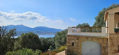 a house with a garage with a view of a lake at Super villa idyllique & antique avec vue mer imprenable in Olmeto