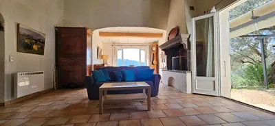 a living room with a blue couch and a table at Super villa idyllique & antique avec vue mer imprenable in Olmeto