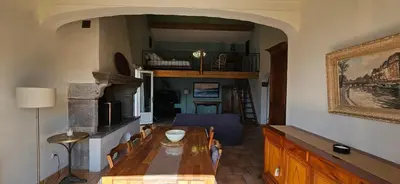 a dining room with a table and a room with a staircase at Super villa idyllique & antique avec vue mer imprenable in Olmeto