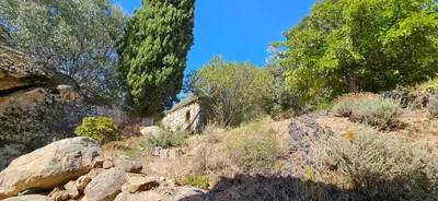 a hillside with trees and rocks and a house at Super villa idyllique & antique avec vue mer imprenable in Olmeto