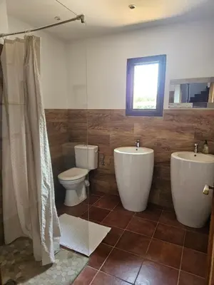 a bathroom with two sinks and a toilet and a shower at Gianni Location Palombaggia in Porto-Vecchio
