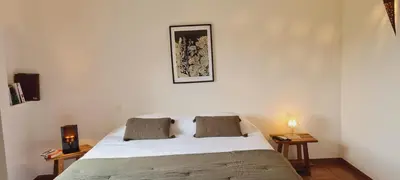 a bedroom with a bed and two tables with lamps at Gianni Location Palombaggia in Porto-Vecchio