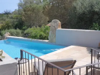 a swimming pool in a yard with aitating at Gianni Location Palombaggia in Porto-Vecchio