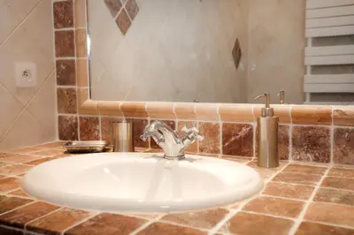 a bathroom sink with a faucet and a mirror at Campu Latinu in Lama