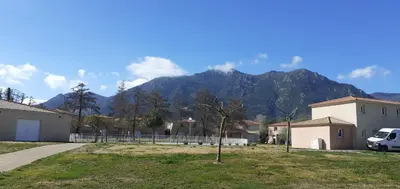 a van parked in a yard with a mountain in the background at Esperanza in Moriani Plage