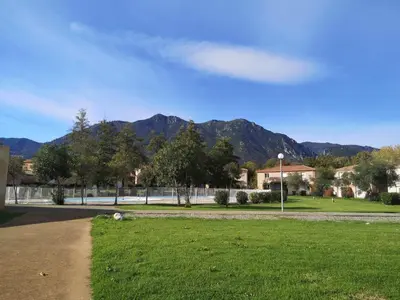a park with a field of grass and mountains in the background at Esperanza in Moriani Plage