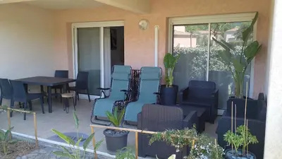 a patio with chairs and a table and a window at Esperanza in Moriani Plage