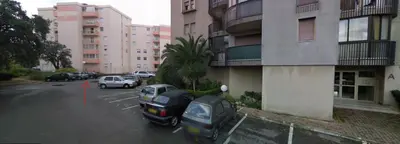 a parking lot with cars parked in front of a building at Beau T3 70m2 Ajaccio in Ajaccio